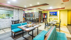A modern hotel lobby with seating areas, a bar, and a television screen. - Hotel Travel Inn (Kathmandu)