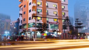 A multi-story hotel with a sign for a travel inn. - Hotel Travel Inn (Kathmandu)