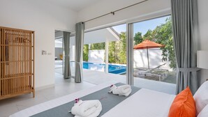 Une chambre d’hôtel moderne avec un grand lit, une armoire en bois et une vue sur une piscine extérieure.