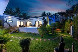 Una casa moderna con piscina, ventanas amplias y jardín cuidado.