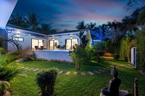 Ein modernes Haus mit Swimmingpool, großen Fenstern und einem gepflegten Garten.