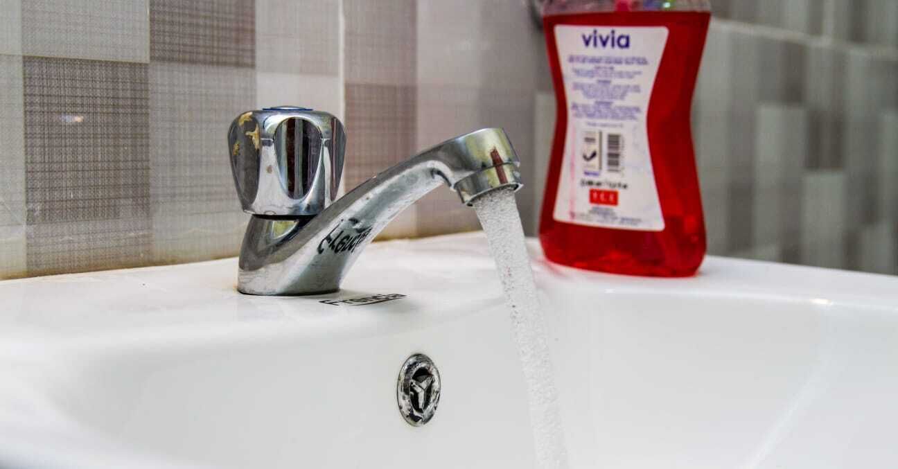Un lavandino da bagno con un rubinetto cromato e una bottiglia di detersivo per piatti Vivia.