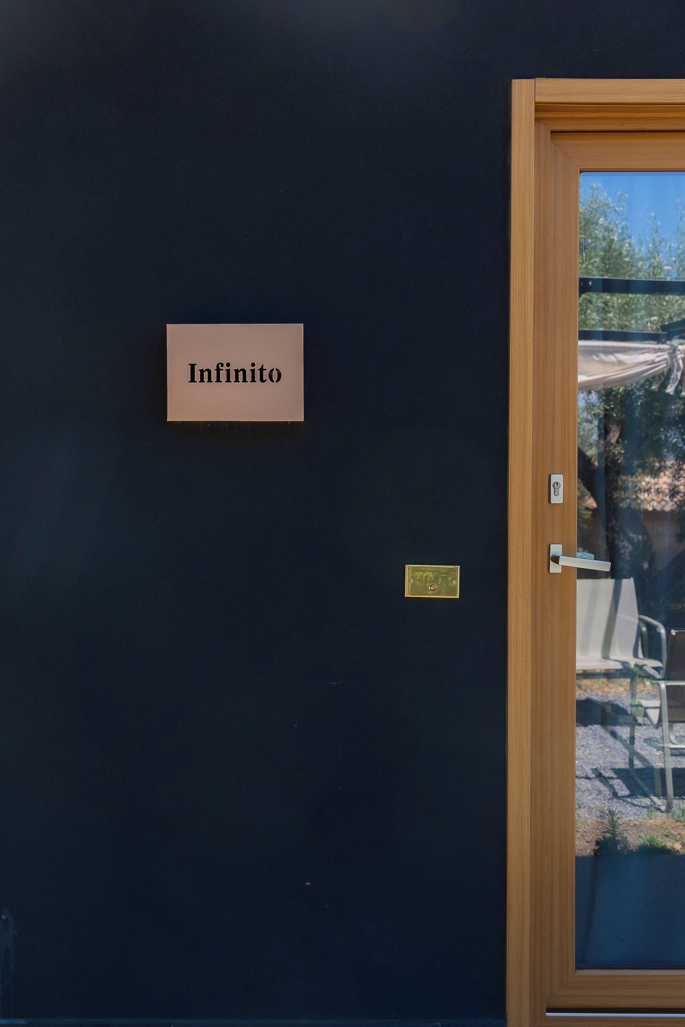 Una puerta con un cartel que dice "Infinito" y una cerradura electrónica.