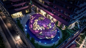 Un edificio moderno con una estructura esférica distintiva, rodeado por un paseo circular.