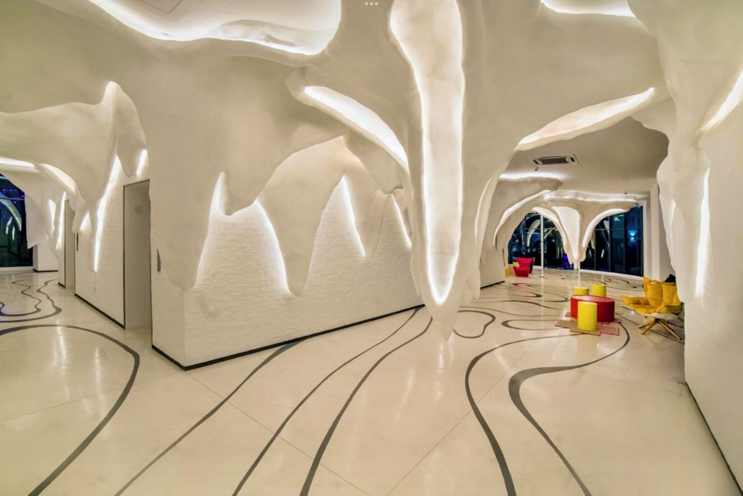 A modern interior with unique wall designs and a clean, minimalist floor pattern.