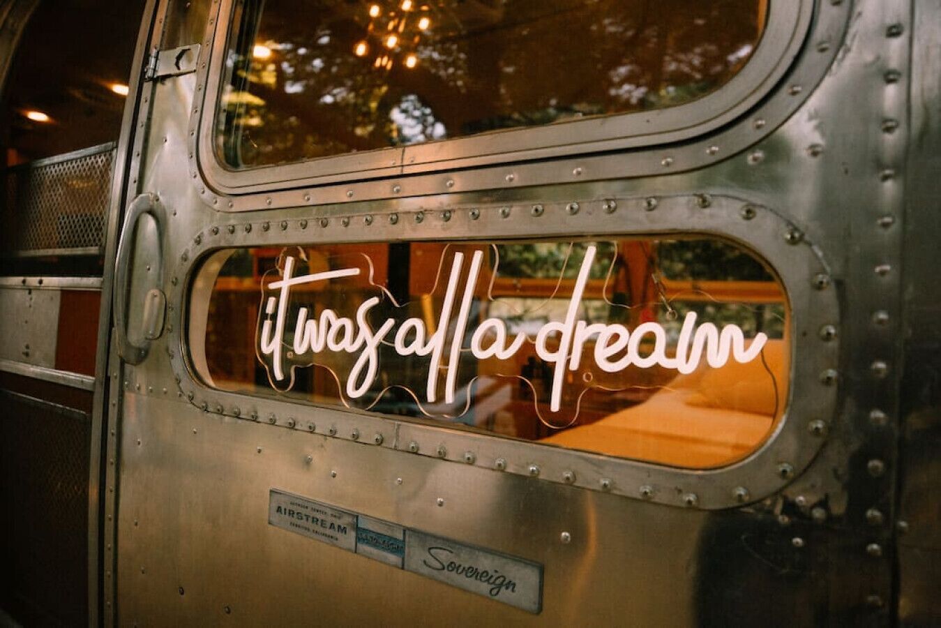 Ein historischer Zugwaggon-Innenraum mit einem Fenster, das den Text 'es war alles nur ein Traum' zeigt.