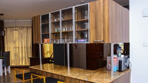 Eine moderne Küche mit einer Granit Arbeitsplatte, Holzschränken und einer integrierten Bar mit Barhocker.