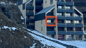 Un hotel moderno de varios pisos con un telesilla al fondo.