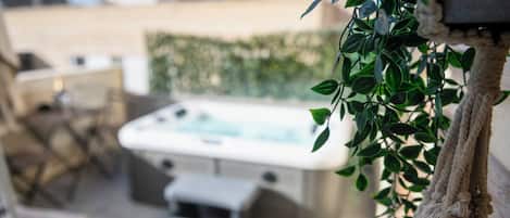 Zona de spa con hidromasaje, asientos y planta colgante.