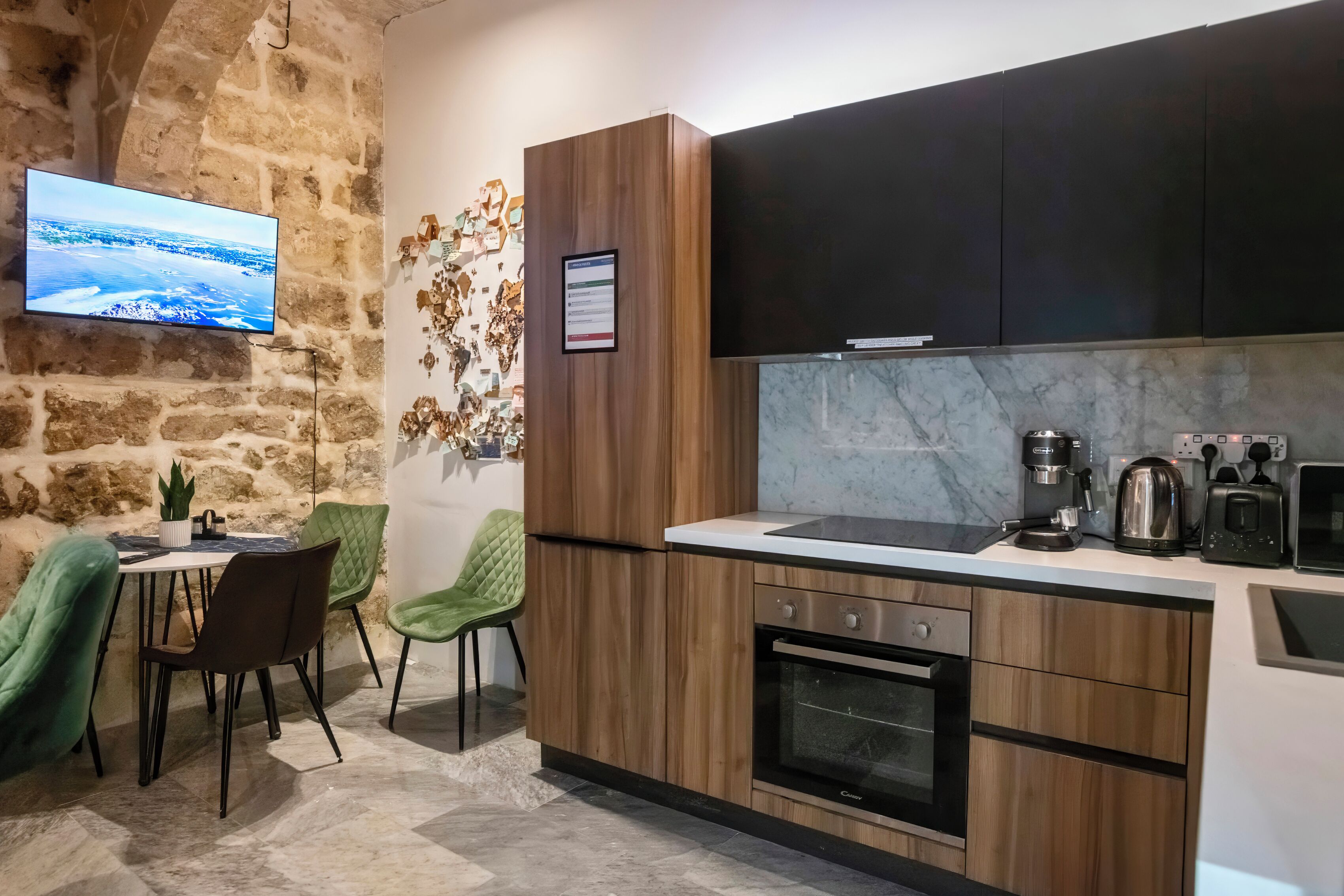 Una cocina moderna con armarios de madera, encimera de mármol y horno empotrado.