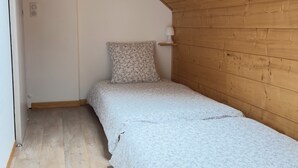 A small, single-bed room with wooden walls and a sloped ceiling. - Climontaine Chalet with Jacuzzi - Vosges Mountains (Colroy-la-Roche)