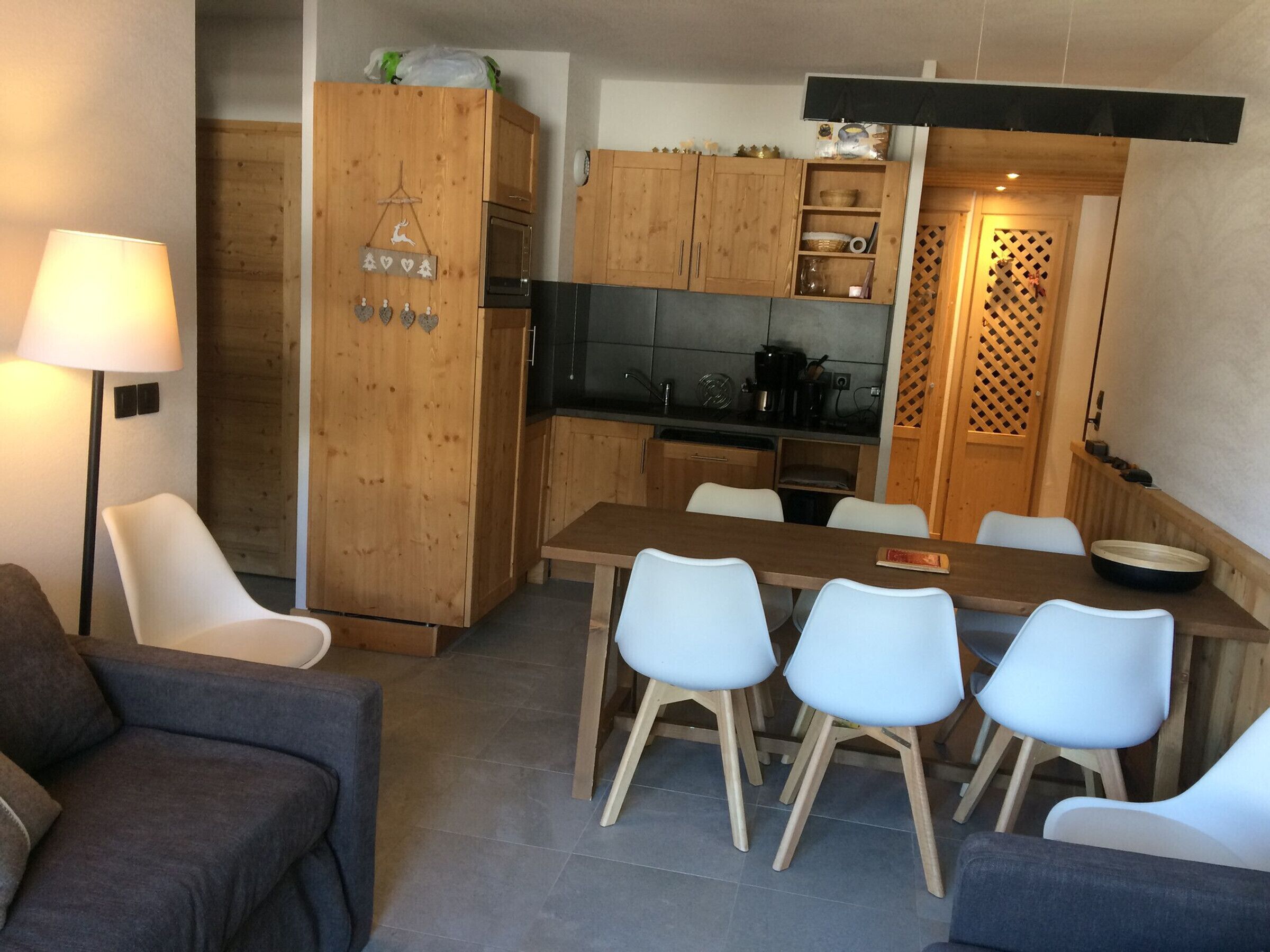 A compact living space with a dining area, kitchenette, and a sofa.