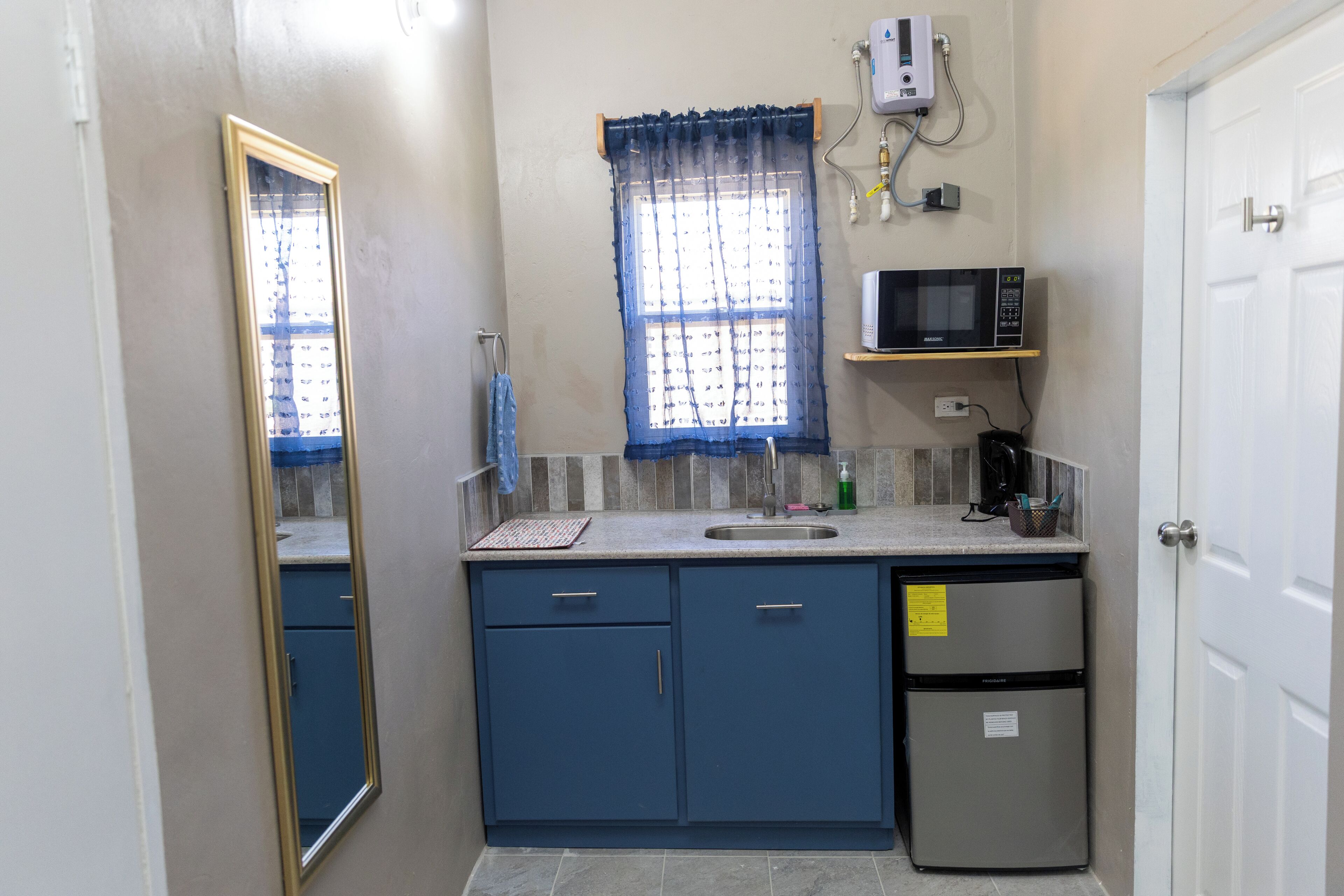 A compact kitchen with a sink, a microwave, and a refrigerator.