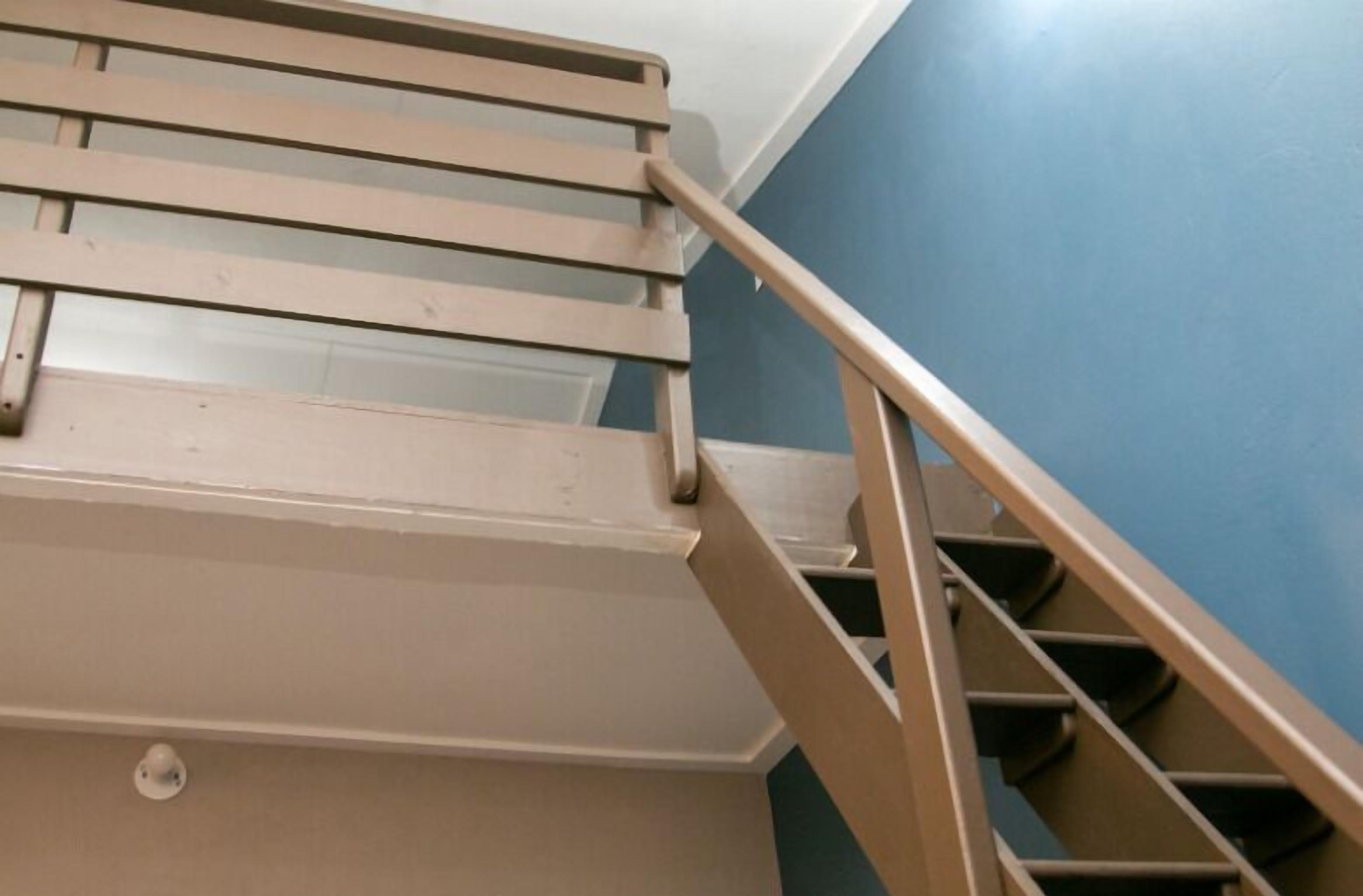 Eine Treppe mit beigen Geländern und einer blauen Wand.