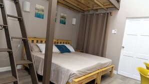Une chambre avec un lit en bois, une échelle, une porte blanche et une chaise jaune.
