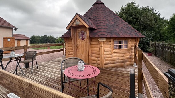A wooden log cabin with a red roof, a small window, and a sign reading "Guest House". - Cozy lodge with SPA, pets allowed and parking (Saint-Léon)