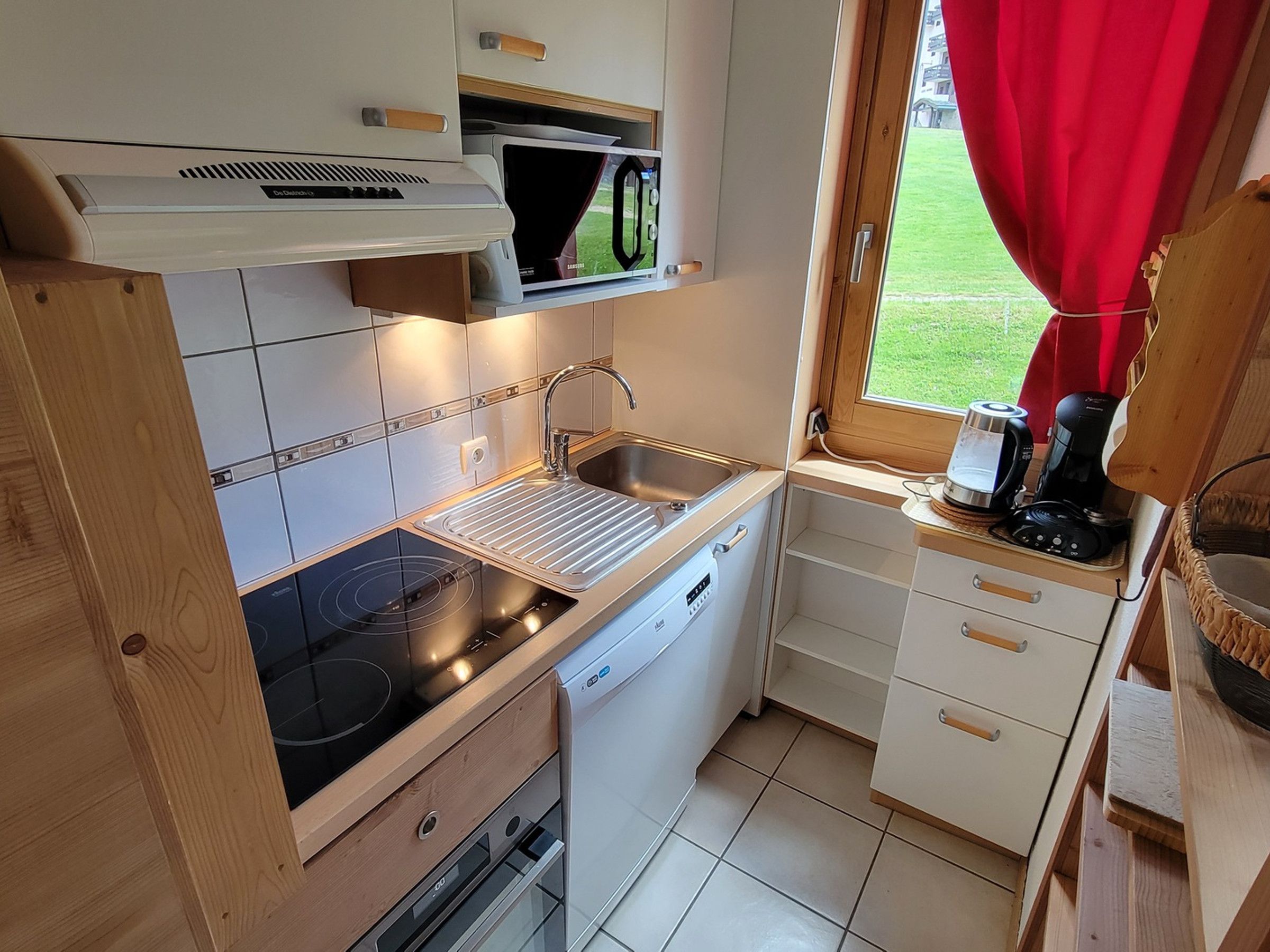 Cocina compacta con microondas, pileta, hornilla y lavavajillas.