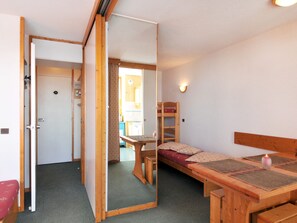 Um quarto com uma cama beliche, uma escrivaninha e uma cadeira.
