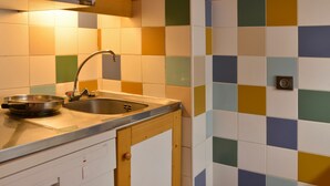 A kitchen with a sink, a microwave, and a colorful tiled backsplash. - Comfortable divisible studio 4 pers, near slopes and shops (Plagne Bellecôte)