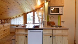 A kitchen with wooden cabinets, a dishwasher, a microwave, and a sink.
