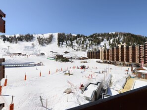 A ski resort with a large building complex, ski lifts, and a snow-covered landscape.