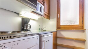 A compact kitchenette with a coffee maker, a small refrigerator, and wooden shelves. - Spacious studio near slopes and center, pets allowed (La Plagne Montchavin Les Coches)