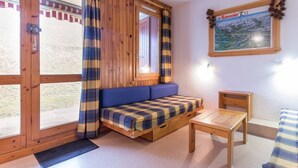 A cozy room with a wooden bench, a small table, and a window with curtains. - Spacious studio near slopes and center, pets allowed (La Plagne Montchavin Les Coches)