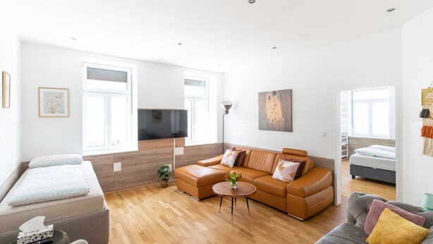 A modern living room with a sofa, a coffee table, and a TV. - Comfortable Apartments Vienna 1100  (Vienna)