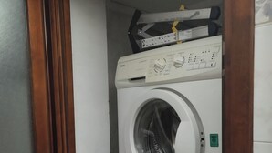 Lavadora compacta integrada, con panel de control, una botella de detergente y una bomba dosificadora.