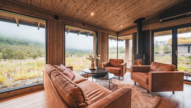 A modern interior with a wooden ceiling, large windows, a fireplace, and a sofa set. - 3 bedroom nice home in Vøringsfoss (Vøringsfoss)