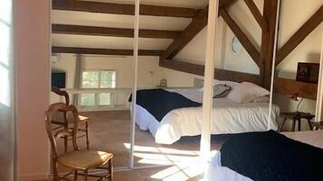 A bedroom with a bed, a chair, and a window.