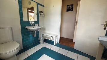 Ein Badezimmer mit Toilette, Waschbecken und Spiegel.
