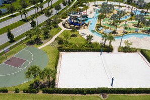 Vista aérea de un espacio recreativo con cancha de baloncesto, piscina y tobogán de agua.