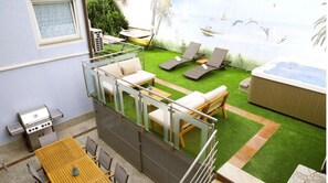 Enjoy a relaxing outdoor space with a clear sea view, featuring a balcony with a sofa, dining table, hot tub, and barbecue grill.