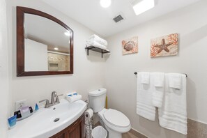 A bathroom with a sink, mirror, toilet, and towel rack.
