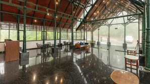 A spacious indoor area with a high ceiling, large windows, and a polished floor. - ELIXIR WOODS RESORT AND SPA (Devikolam)