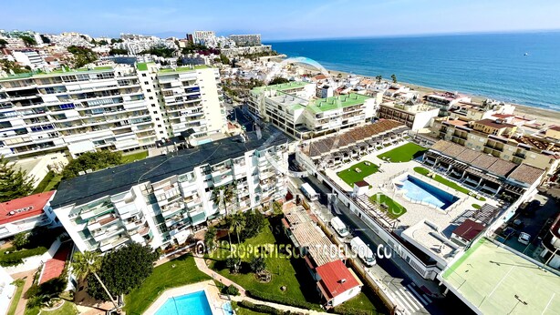 A high-rise hotel with multiple balconies, a swimming pool, and a view of the sea. - 2 bedrooms apartment in front of the sea with stunning views! (Torremolinos)