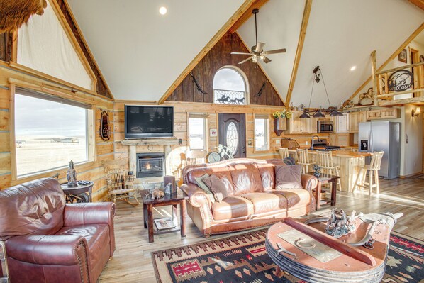 A spacious living room with a fireplace, leather furniture, and a large TV. - Roberts Home w/ Western Decor & Mountain Views! (Roberts)