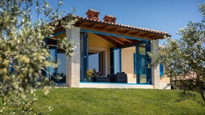 A small, single-story house with a tiled roof, a stone foundation, and blue-framed windows. - Luxurious home in Fazana (Fazana)