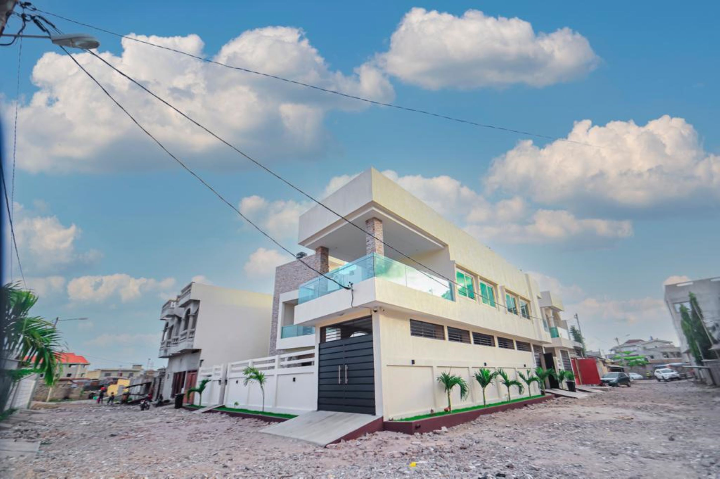 A modern two-story building with a flat roof, a balcony, and a garage.