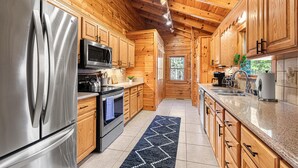 Une cuisine moderne avec des meubles en bois, des appareils électroménagers en acier inoxydable et un plan de travail en granit.