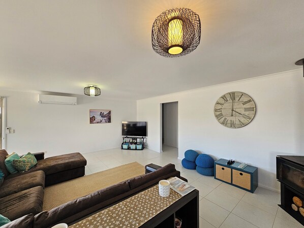 A modern living room with a sofa, coffee table, TV, and decorative items.