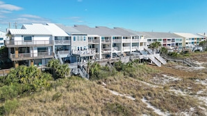 A beachfront hotel with multiple balconies, a boardwalk, and a sandy beach. - Luxury Beach Front Townhouse – 4BR/3.5 BA Slps 14! (Panama City Beach)