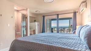 A bedroom with a large bed, a sliding door to a balcony, and a view of the sea. - Luxury Beach Front Townhouse – 4BR/3.5 BA Slps 14! (Panama City Beach)