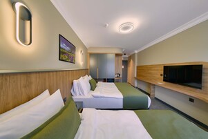 Habitación de hotel con dos camas, televisión, cabecero de madera y un cuadro en la pared.