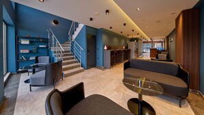 A modern lobby with a staircase, seating area, and a bar. - Rest by Dedeman Karabuk (Karabük)