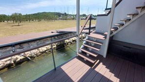 A modern outdoor staircase leading to a deck with a view of a marina and a grassy area. - OLIVA HOUSE BOAT - Unique Experience near Beaches, Amenities, Fun and History (Pula)
