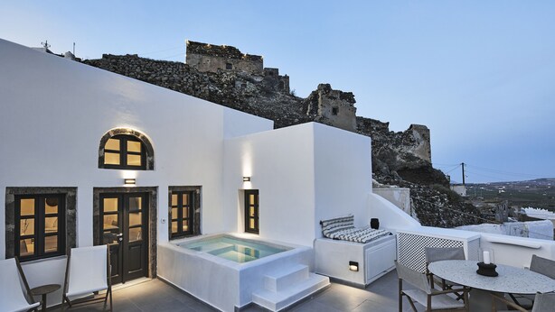 A rooftop terrace with a pool, seating area, and a view of a historic stone wall. - Lerion Luxury Villas (Santorini)