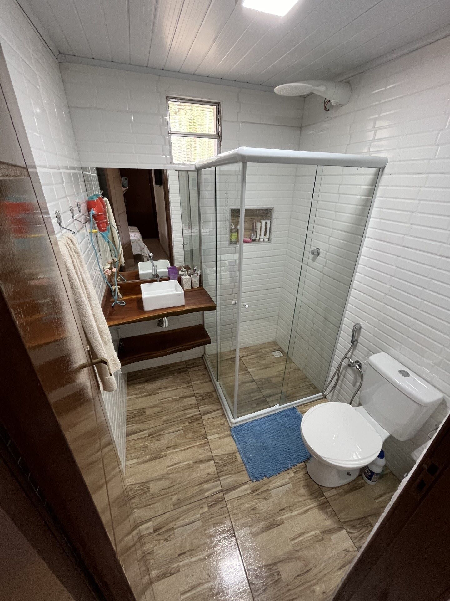 Chuveiro, secador de cabelo, toalhas de banho, papel higiênico