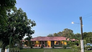 A building with a red-tiled roof, a paved pathway leading to the entrance, and a well-maintained lawn.